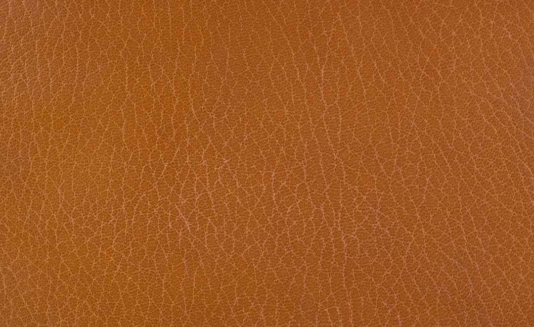 Close-up of top-grain brown leather showing the natural grain texture